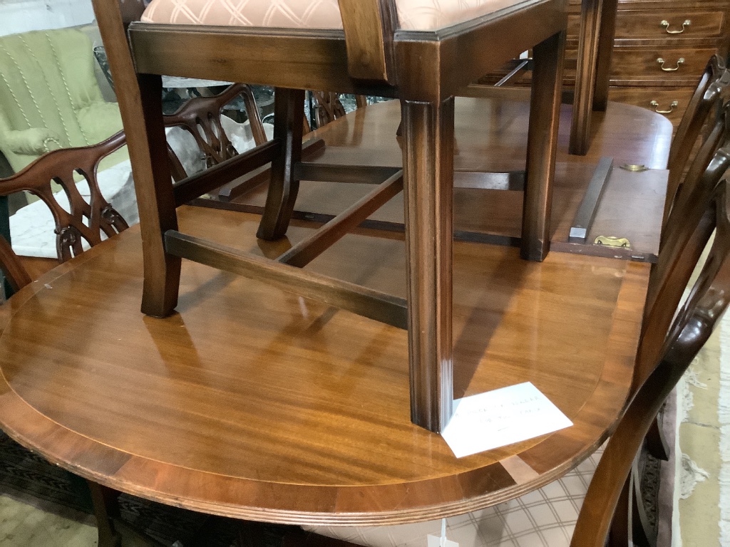 A George III style D-end twin-pedestal dining table and a set of eight George III style mahogany dining chairs, two with arms, table width 245cm extended (two spare leaves)